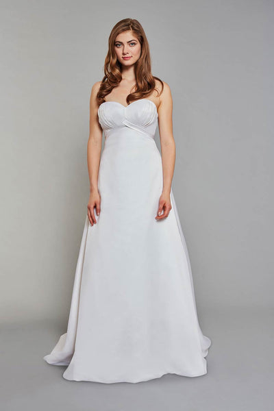 Bride wearing strapless gown with an empire waist and subtle pleated detailing on the bodice wedding dress
