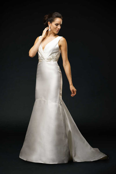 Bride wearing wedding gown with Silk mikado, V-neck bodice, gathered at the empire waist.