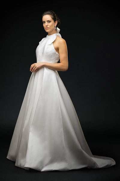 Bride wearing silk mikado halter dress with lace detailing on the front bodice and gathered bow neckline wedding dress