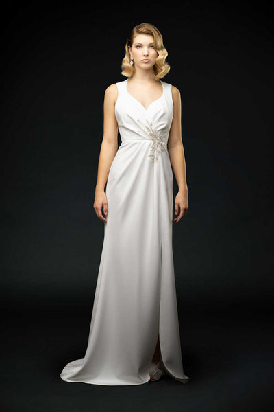 Silk crepe sheath dress with pleated and feather embroidery detail. Sexy slit and low-cut exposed back wedding gown front view